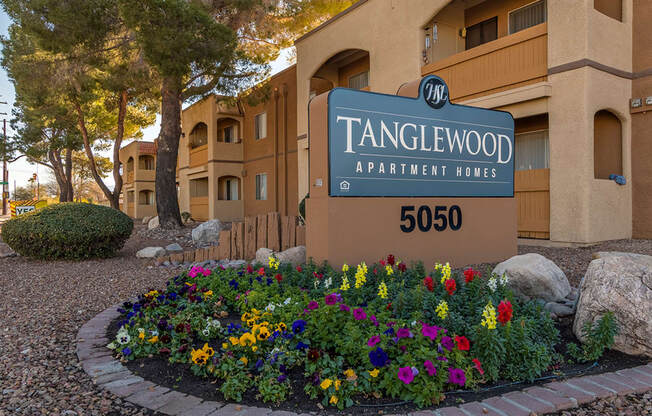Tanglewood community sign with well kept entrance and flowers all around