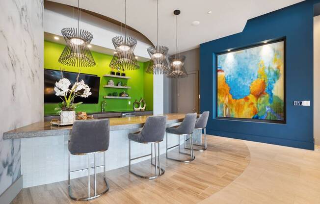 a kitchen with a bar and chairs and a painting on the wall