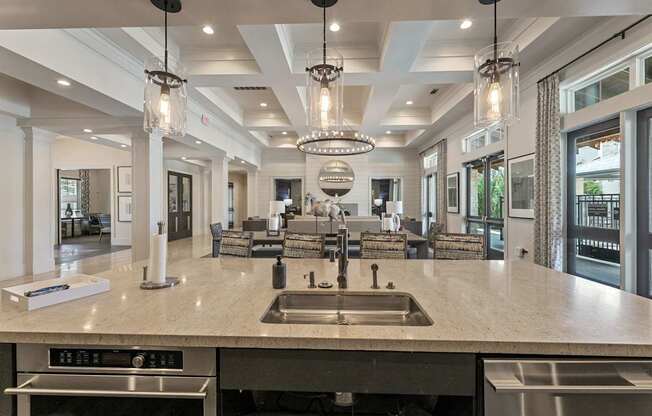 A modern kitchen with a large island and pendant lights.