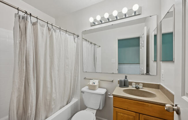 a bathroom with a shower and a sink and a toilet