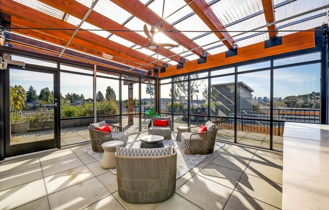 The Hayes on Stone Way Apartments patio with wicker chairs and a glass roof at The Hayes on Stone Way, Seattle, WA, 98103