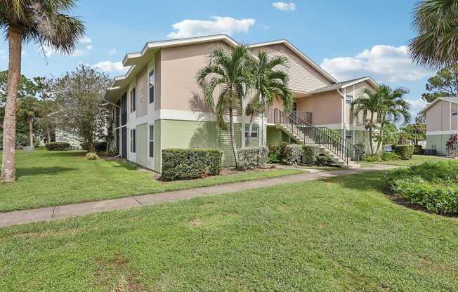 A house with a green lawn and a tree in front.
