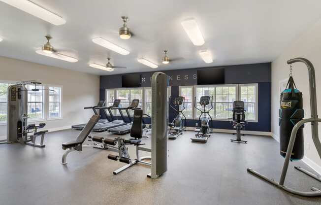 a gym with exercise equipment and windows and lights on the ceiling