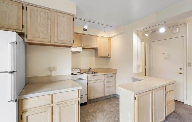 a kitchen with white appliances and wooden cabinets