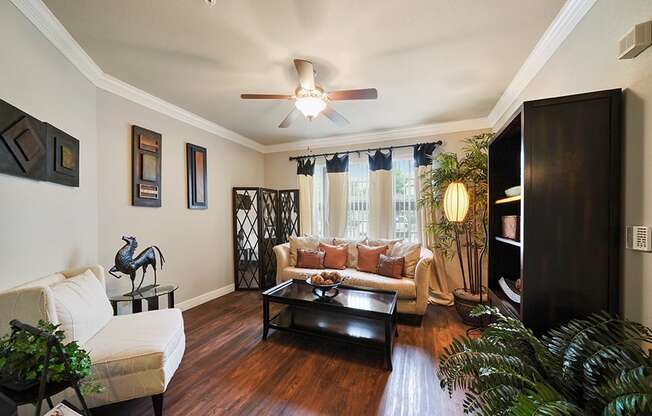 A living room with a white couch and a wooden floor.