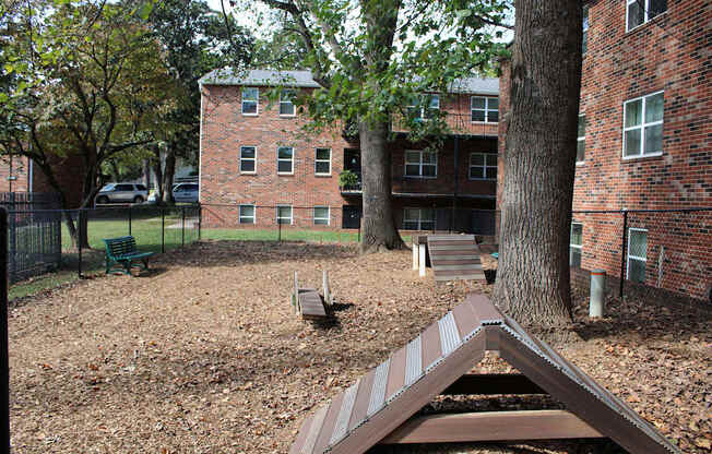 A playground with a slide in front of a brick building.