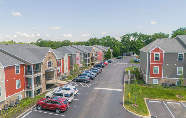 an aerial view of an apartment complex with cars parked on the street