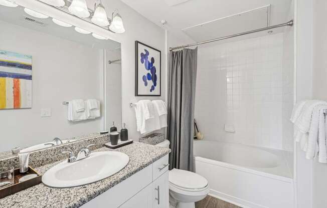 A bathroom with a white toilet, sink, and bathtub.