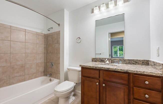 A bathroom with a toilet, sink, and tub.