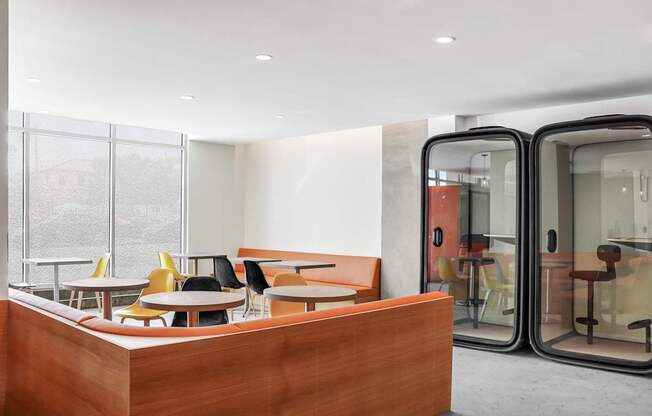a seating area with tables and chairs in front of a glass door