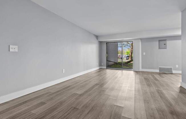 A room with light wood flooring and white walls.