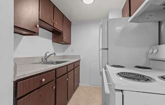 an empty kitchen with a stove refrigerator and sink