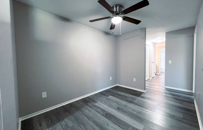 a living room with gray walls and a ceiling fan