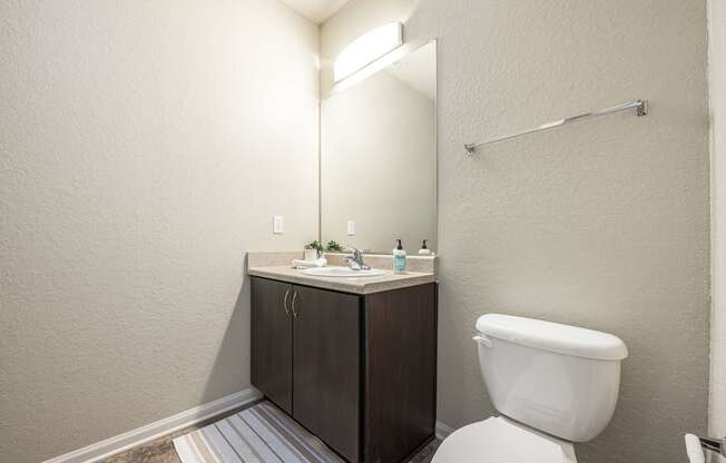 A white toilet sits next to a sink in a small bathroom.