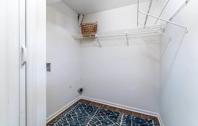 a closet in a bedroom with a white wall and a hanging rack