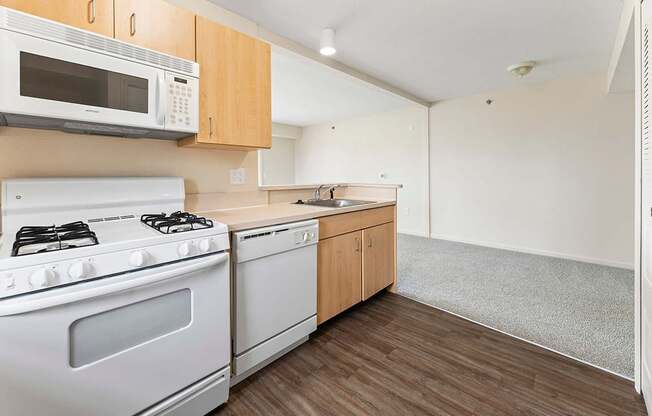 A kitchen with a white stove and microwave above it at Fieldstream Apartment Homes in IA 50023