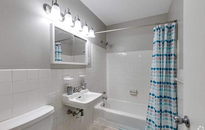 A white bathroom with a white tub and sink.