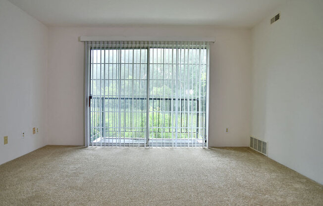 Living Room With Balcony Access at Charter Oaks Apartments, Davison, MI