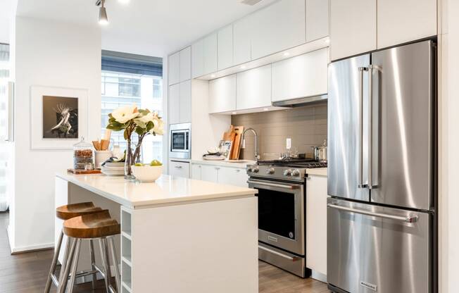 a white kitchen with stainless steel appliances and a counter top