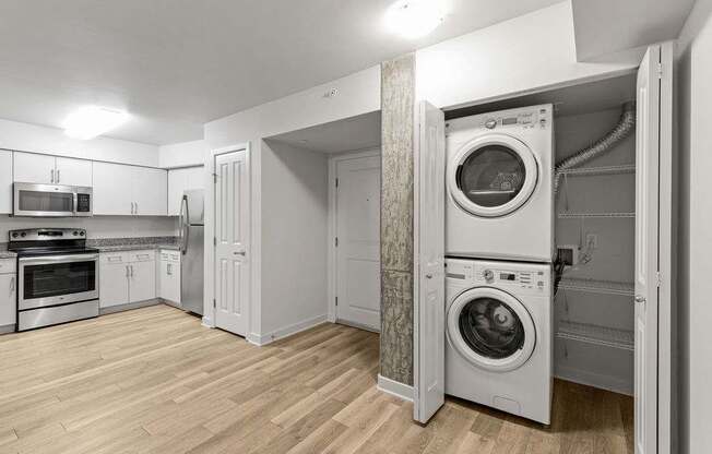 A modern kitchen with a washing machine in the wall.