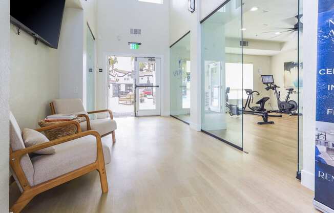 a waiting room at a hospital with chairs and glass doors