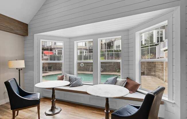 a screened in porch with tables and chairs and a pool