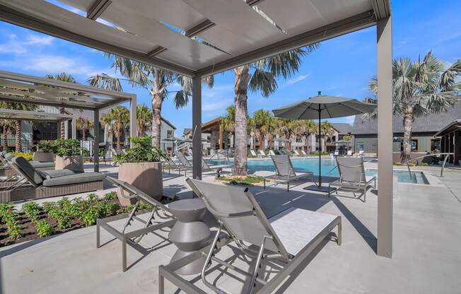 a patio with chairs and umbrellas next to a pool at Canter, Ocala, FL, 34474