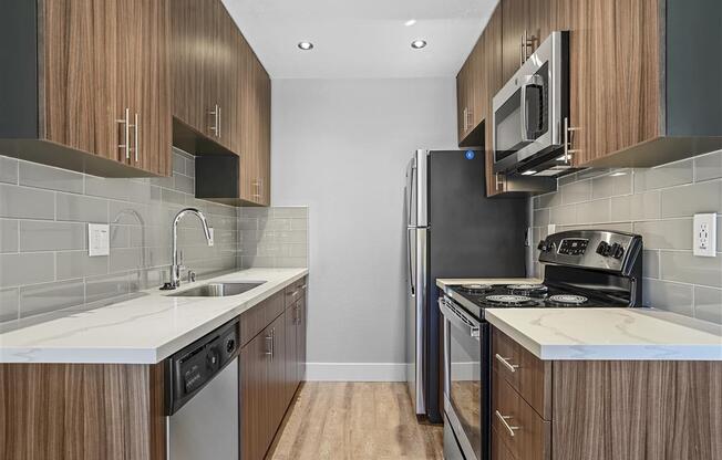 Fully Equipped Kitchen Includes Frost-Free Refrigerator, Electric Range, & Dishwasher at Peninsula Pines Apartments, California