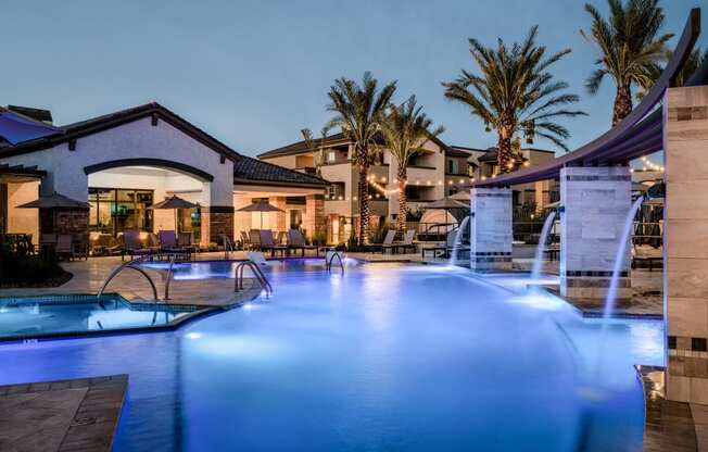 a swimming pool with blue lights at night at the resort