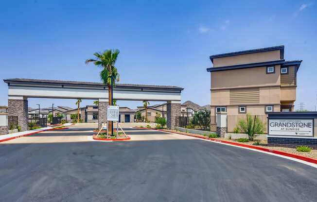 a building with a palm tree in front of a parking lot at Grandstone at Sunrise, Arizona