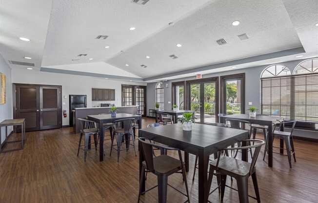 a community room with tables and chairs and a kitchen