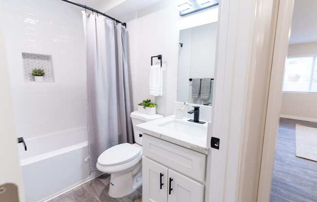 a bathroom with a white sink and toilet and a shower