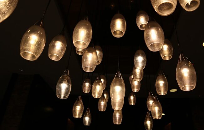 a bunch of lights hanging from the ceiling in a dark room