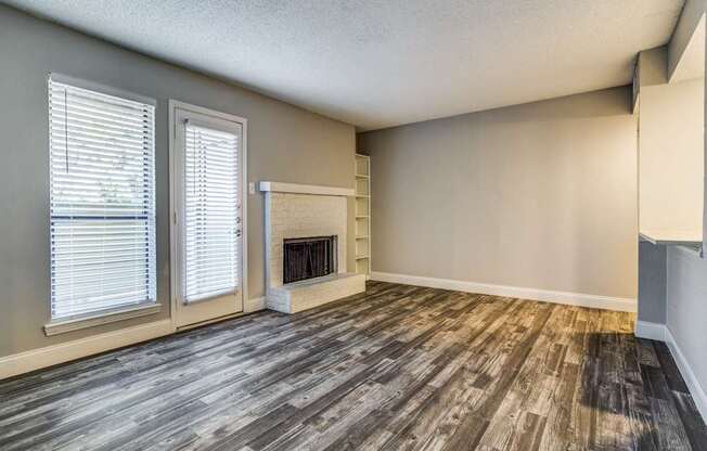 A room with a fireplace and wood flooring.