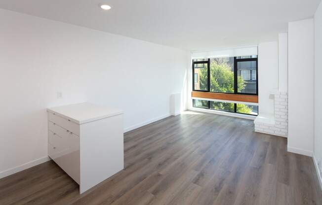 an empty room with white walls and a large window