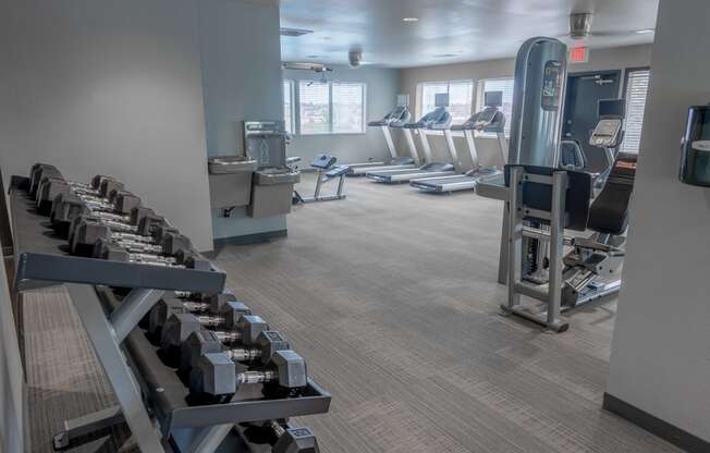 a gym with cardio equipment and chairs in it