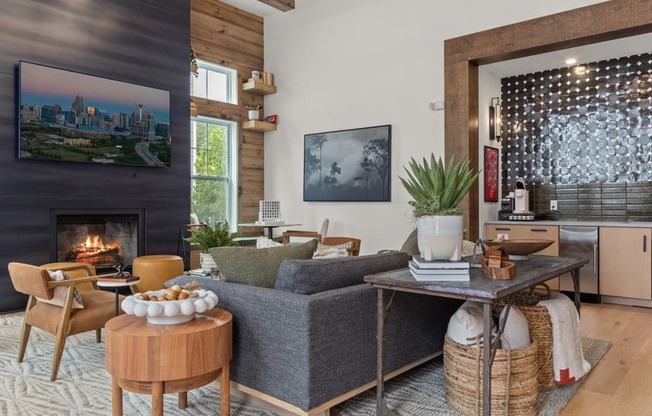 A living room with a fireplace and a grey couch.
