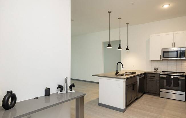 Modern kitchen in a Florida apartment featuring an island, stove, and microwave.