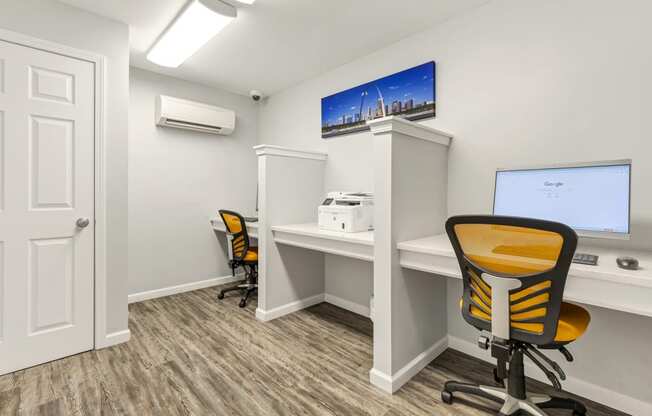 an office with a computer and a desk with a chair