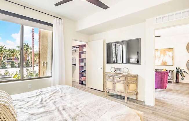 A bedroom with a bed, a dresser, and a ceiling fan.