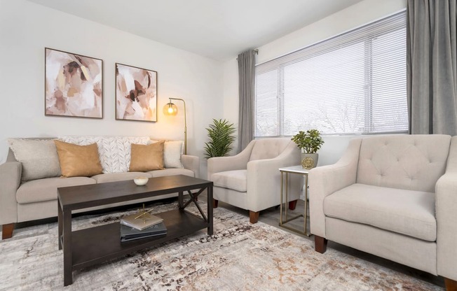 living room with neutral color sofa and chairs and a dark wood center coffee table