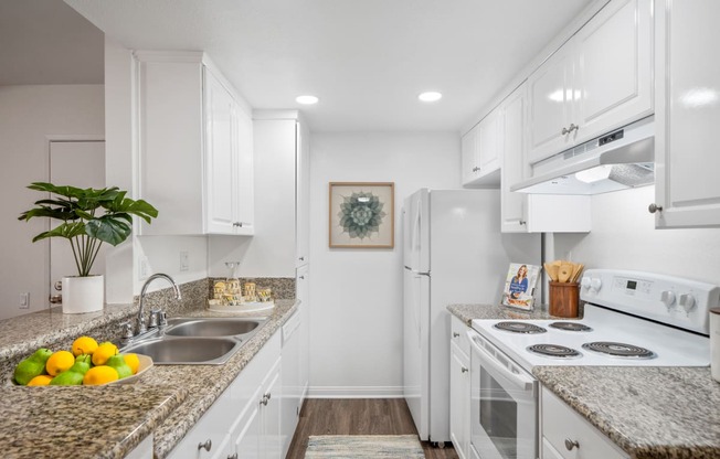 a kitchen with white cabinetry and granite countertops