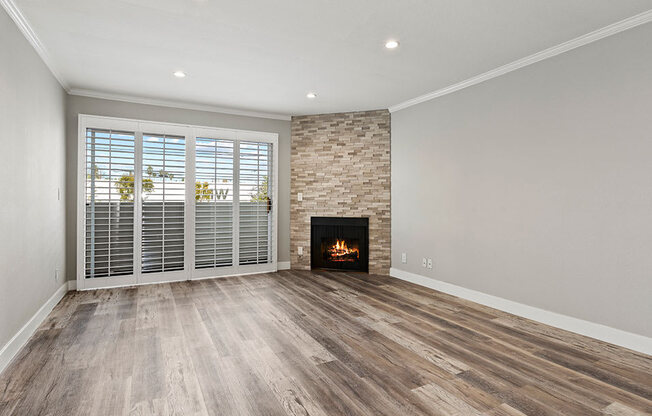 Hardwood floored living room with stone accented fireplace.