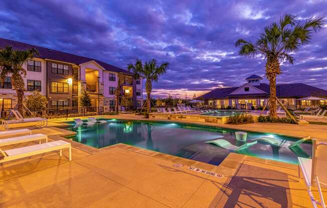 Swimming pool with palm trees at night at The Parker Austin, Pflugerville, Texas