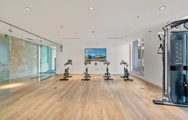 a large room with exercise machines and a painting on the wall