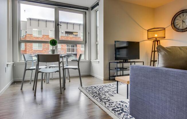 a living room with a large window and a table with chairs