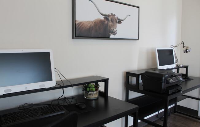 a desk with a computer and a picture of a bull on the wall