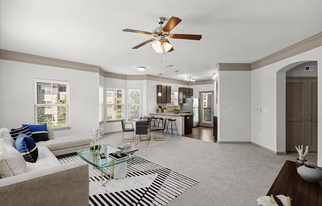 a living room with a couch a table and a ceiling fan