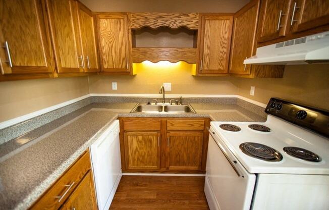 wood cabinets, white stove and dishwasher in kitchen