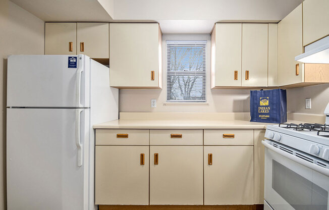 a kitchen with white appliances and a window